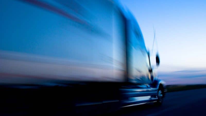 Truck speeding down the freeway at dusk